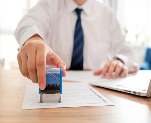 A notary applying a stamp to a legal document